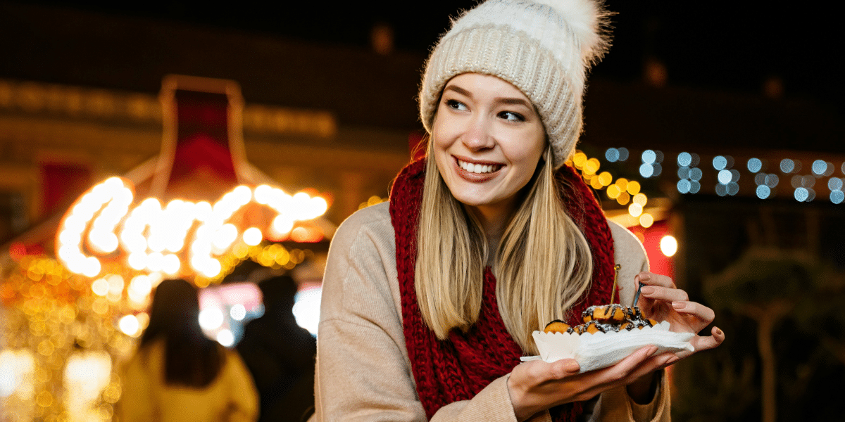 woman in sweater holding a sweet treat